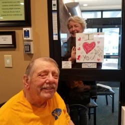 A window visit with sign that says I Love You